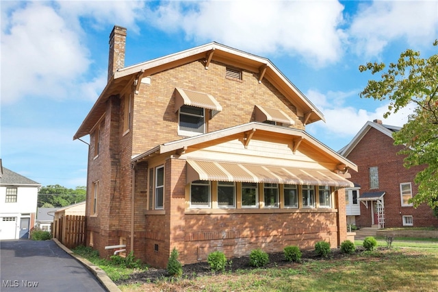 view of front of home with brick siding and a chimney