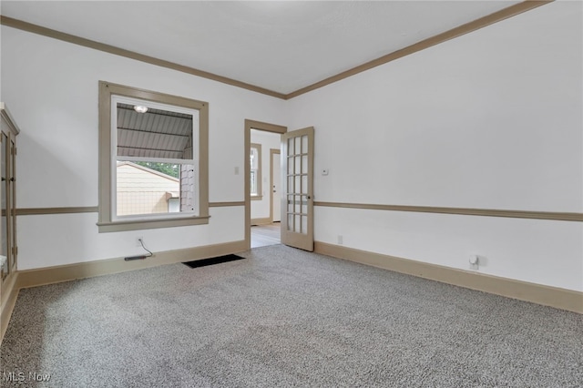 empty room featuring baseboards, french doors, carpet, and crown molding