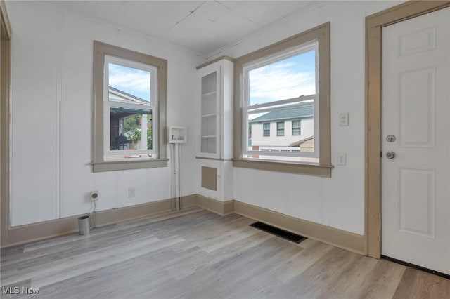 doorway to outside with light wood-style floors, visible vents, and baseboards