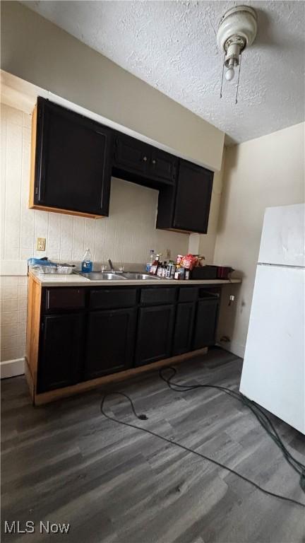 1227 E 113th St, Cleveland, OH 44108 - kitchen with a textured ceiling, wood finished floors, a sink, light countertops, and freestanding refrigerator