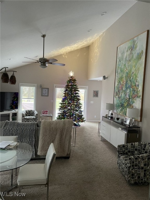 living area with lofted ceiling, carpet, and ceiling fan