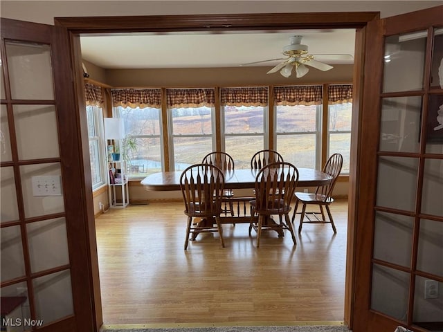 dining area with light wood-type flooring and a ceiling fan