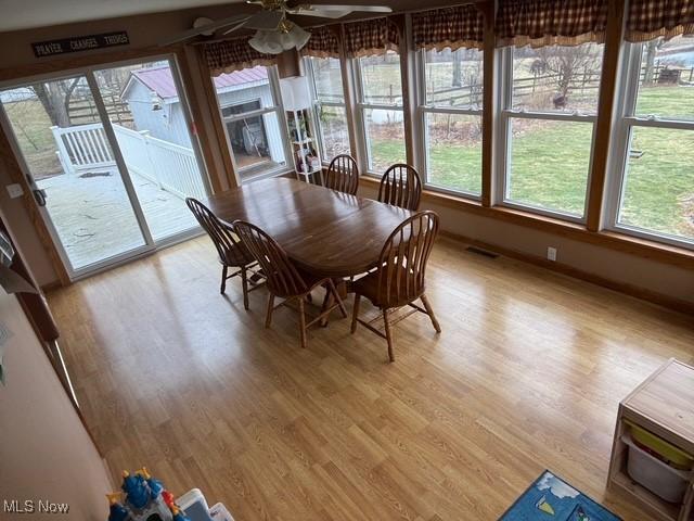 unfurnished dining area with visible vents, ceiling fan, light wood-style flooring, and a wealth of natural light