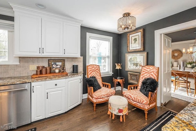 sitting room with dark wood-type flooring, an inviting chandelier, and a healthy amount of sunlight