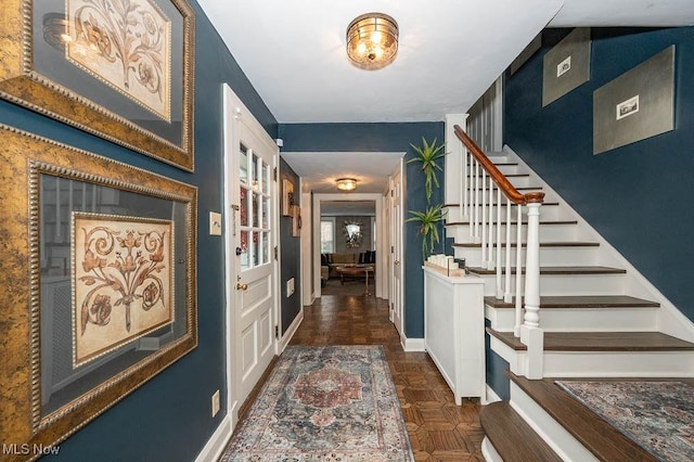 entrance foyer featuring stairway and baseboards