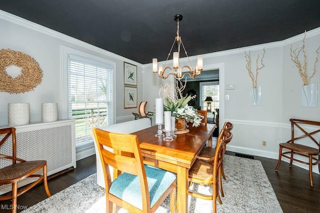 dining space with a chandelier, ornamental molding, dark wood finished floors, and baseboards