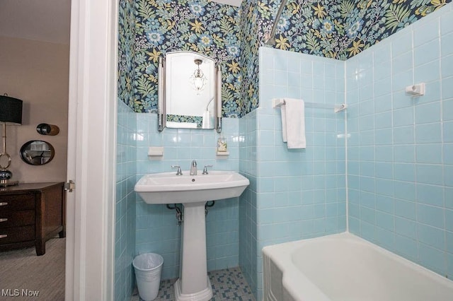 bathroom featuring wallpapered walls, tile walls, and a wainscoted wall