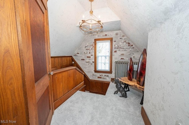 additional living space with light carpet, an inviting chandelier, a textured ceiling, and lofted ceiling