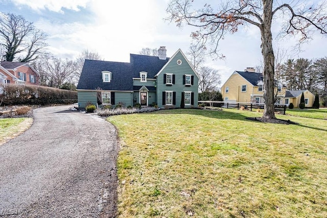 view of front of property featuring a front yard, fence, and a chimney