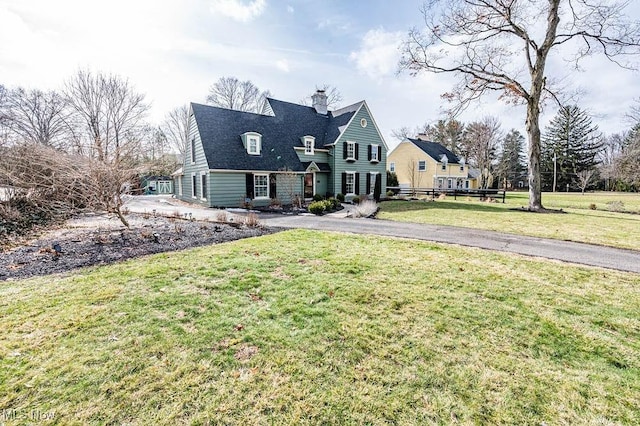 view of front of home featuring a front lawn and a chimney