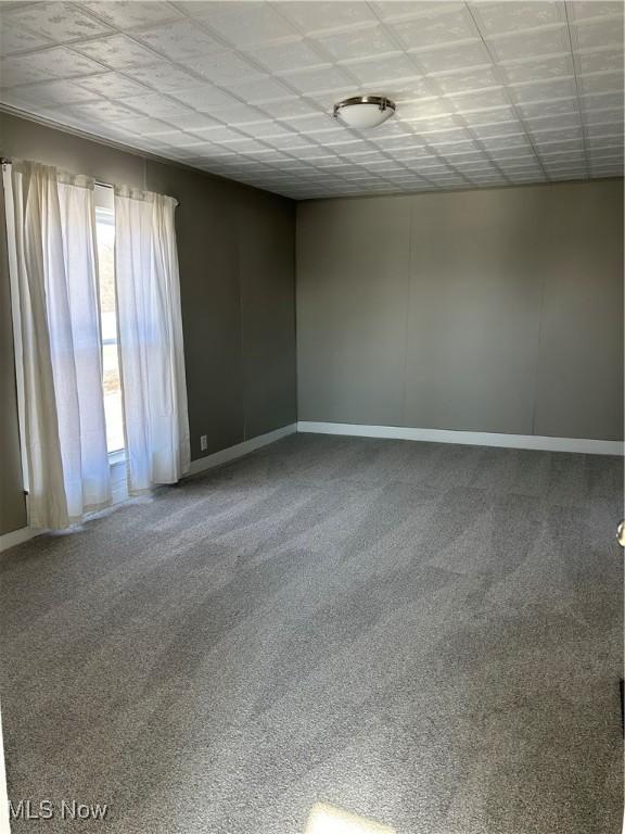 carpeted spare room with baseboards