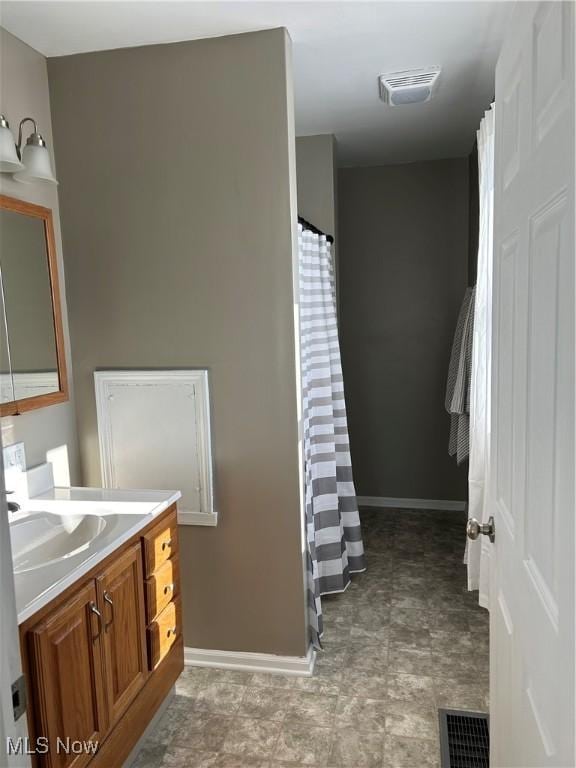 full bath with vanity, visible vents, and baseboards