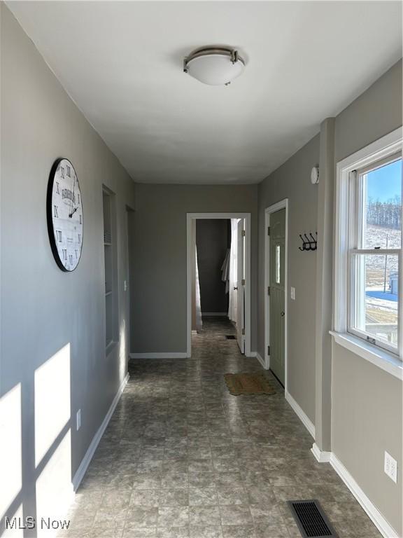 corridor with built in shelves, visible vents, and baseboards