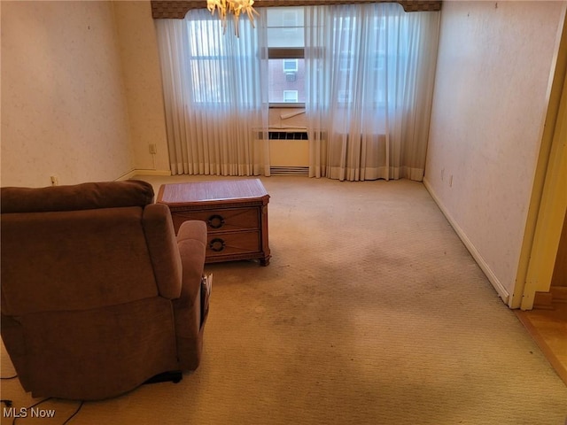 living area featuring radiator, light carpet, and baseboards