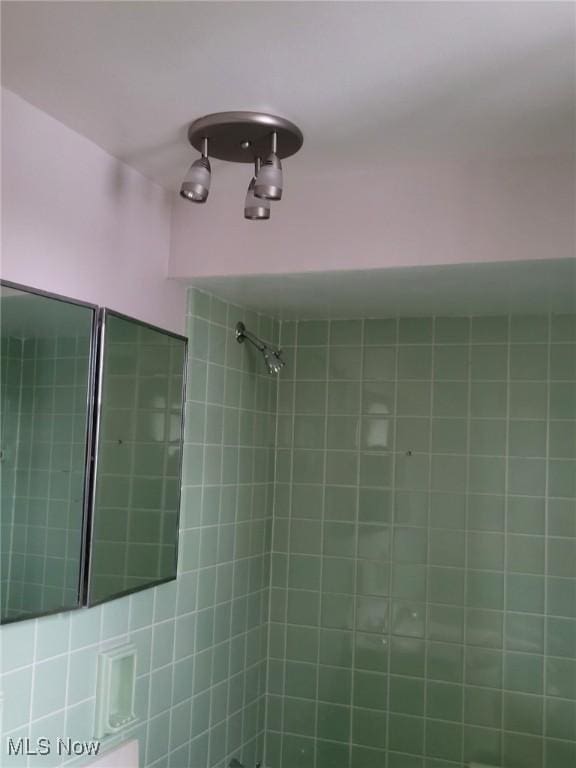 full bathroom featuring tiled shower