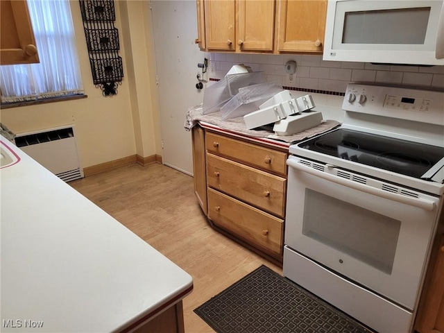 kitchen with white appliances, tasteful backsplash, light countertops, and light wood-style floors