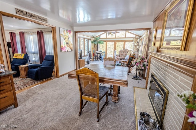 dining space featuring baseboards, carpet floors, a fireplace with flush hearth, and a healthy amount of sunlight