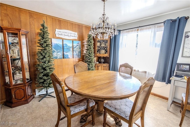 dining area with light carpet, wood walls, and a notable chandelier