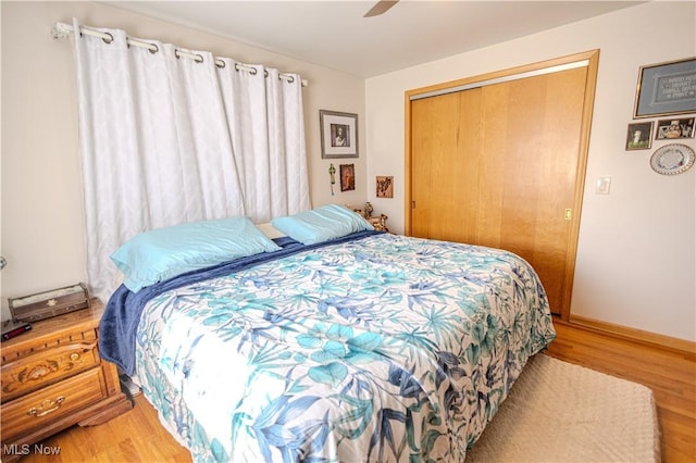 bedroom with baseboards, a closet, a ceiling fan, and wood finished floors