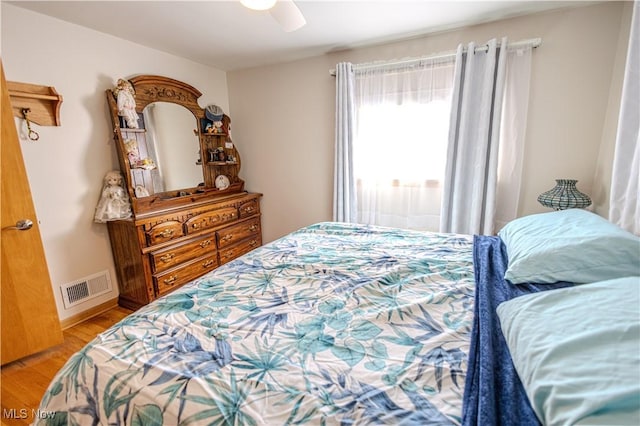 bedroom with visible vents, ceiling fan, baseboards, and wood finished floors