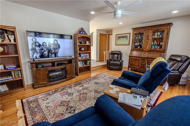 living room with light wood-type flooring, baseboards, a ceiling fan, and recessed lighting