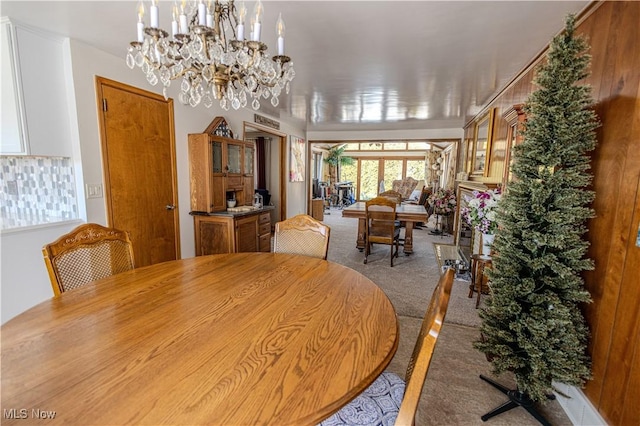 dining space featuring carpet floors and a chandelier