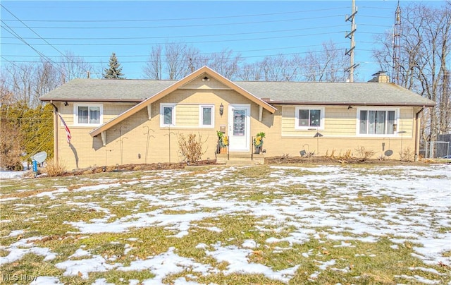 view of front of property featuring a chimney and brick siding