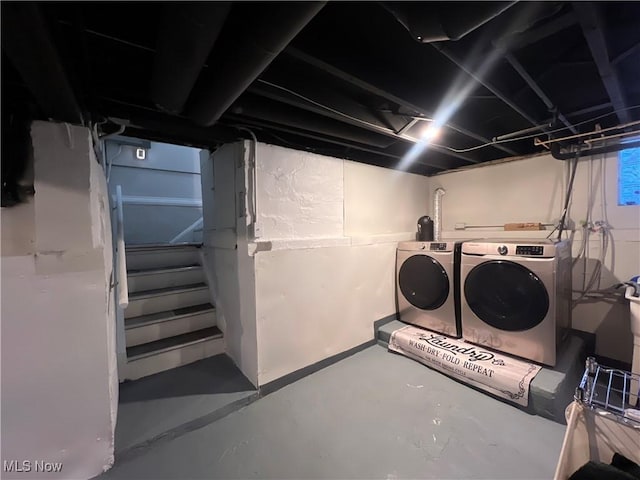 unfinished basement with separate washer and dryer and stairway