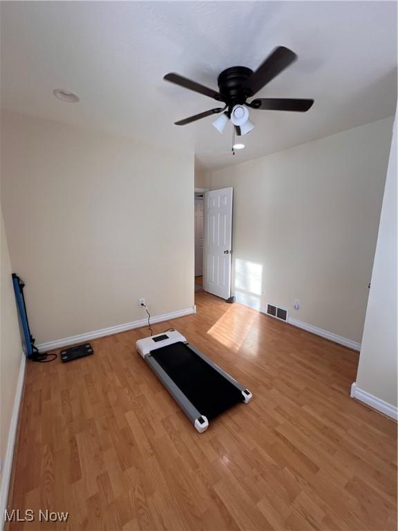 workout area featuring light wood-type flooring, baseboards, and visible vents