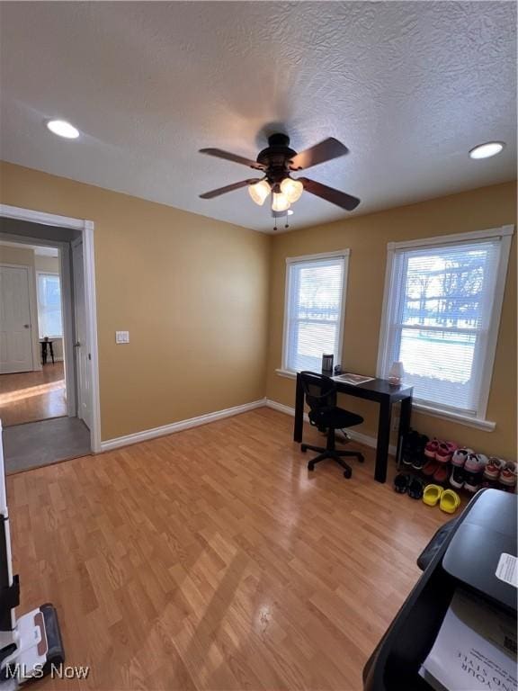 home office featuring recessed lighting, light wood-style floors, a ceiling fan, a textured ceiling, and baseboards