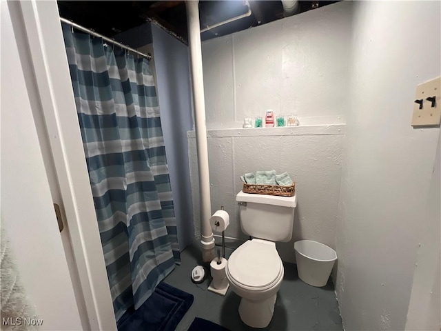 full bathroom with a shower with curtain, concrete floors, and toilet