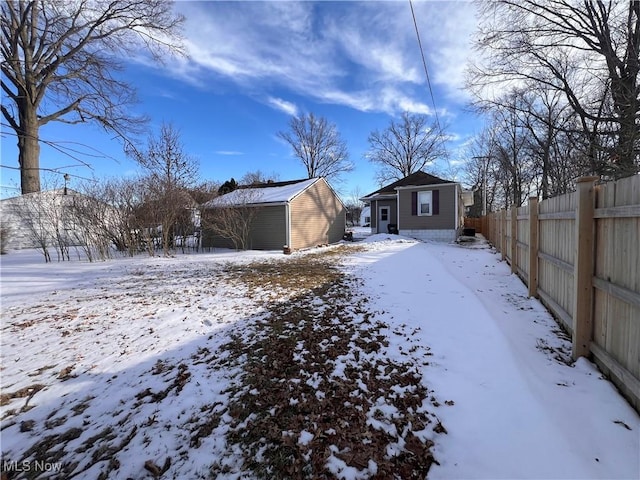 exterior space featuring fence, a detached garage, and an outdoor structure