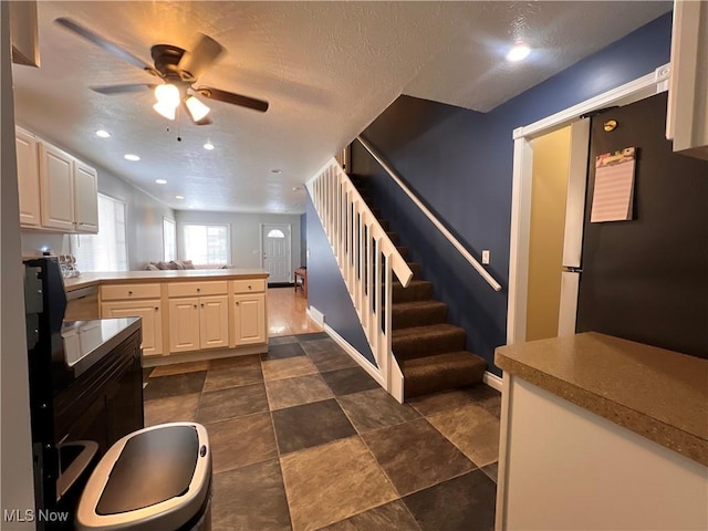 kitchen with a peninsula, baseboards, a ceiling fan, and freestanding refrigerator