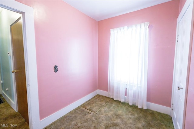 spare room featuring baseboards and carpet flooring