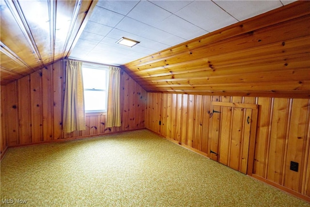 bonus room with lofted ceiling, carpet flooring, and wooden walls