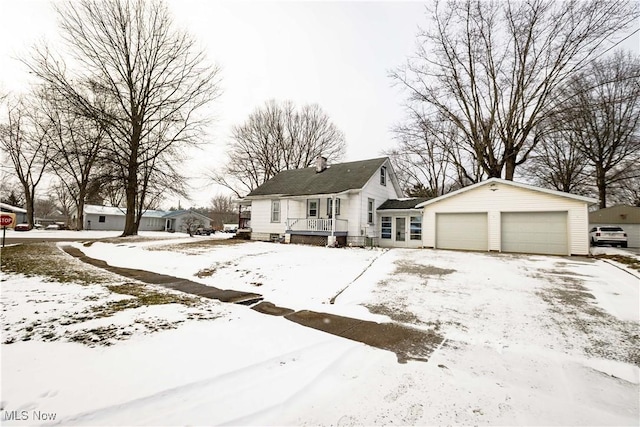 bungalow featuring a detached garage and a chimney