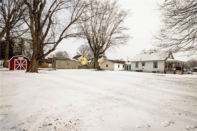 snowy yard featuring an outdoor structure and a shed