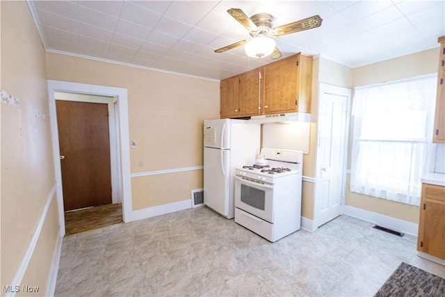 kitchen with white appliances, brown cabinetry, visible vents, and baseboards