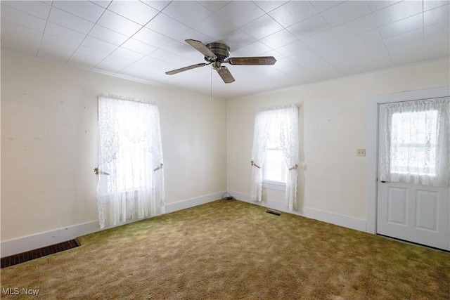 unfurnished room featuring ceiling fan, visible vents, baseboards, and carpet flooring