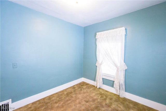 unfurnished room featuring carpet flooring, visible vents, and baseboards