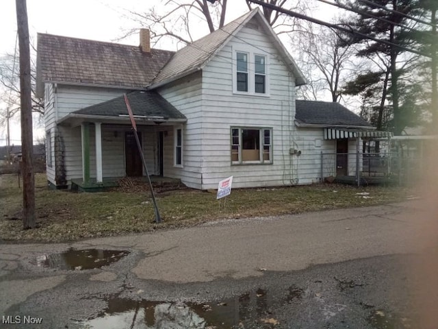 view of front of house with a chimney and a front lawn