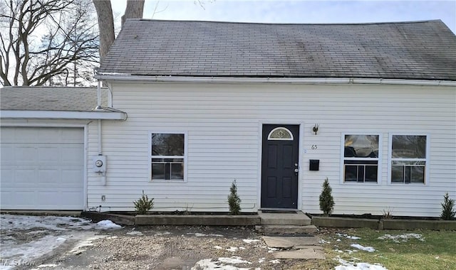 view of front of house with a shingled roof and an attached garage