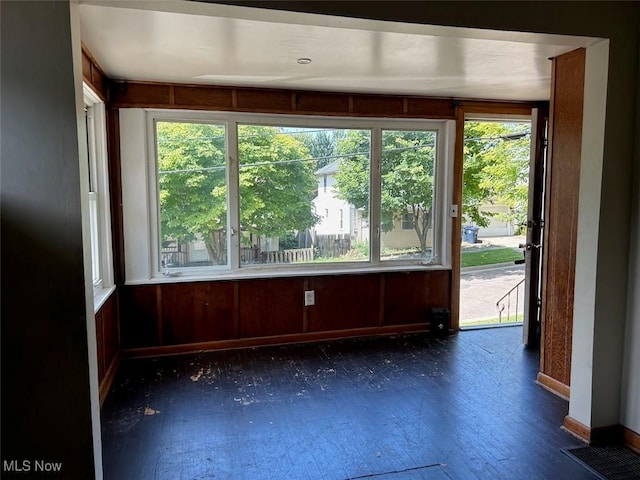 interior space with wood walls, plenty of natural light, and baseboards