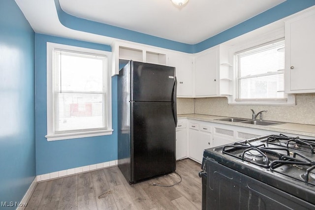 kitchen featuring open shelves, a sink, white cabinets, light countertops, and black appliances