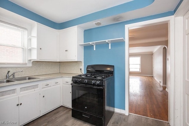 kitchen featuring black gas range, white cabinets, open shelves, and light countertops