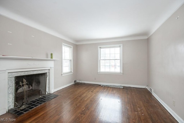 unfurnished living room featuring baseboards, dark wood-style flooring, and a high end fireplace