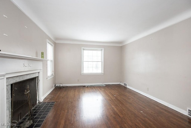 unfurnished living room with visible vents, a fireplace, baseboards, and dark wood-style flooring