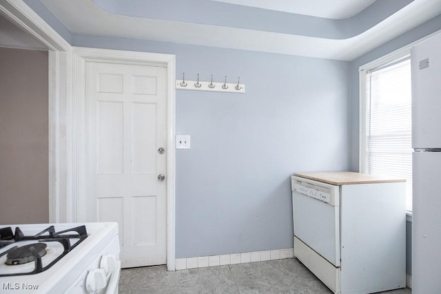 kitchen with white appliances, baseboards, and light countertops