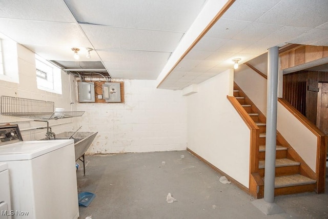 basement with concrete block wall, washer / dryer, electric panel, and stairway