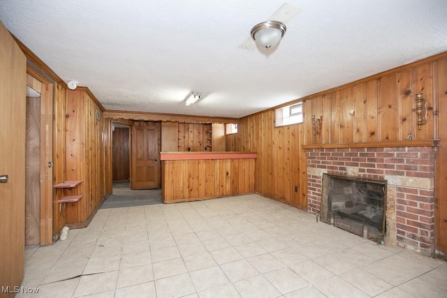 unfurnished living room featuring a bar, a fireplace, and wooden walls